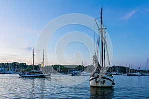 Sailing ships on the river Warnow in the sunset during the Hanse Sail in Rostock, Germany