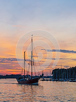 Sailing ships on the river Warnow in the sunset during the Hanse Sail in Rostock, Germany