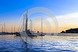 Sailing ships at sea at sunset.