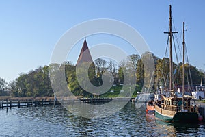 Sailing ships in the yacht port in front of the church on the island Poel near Wismar in the Baltic Sea, Germany, blue sky with