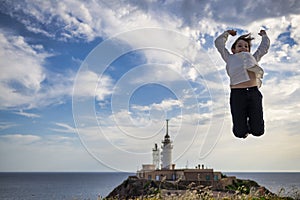 Sailing into Success: A Boy\'s Joyful Jump by the Lighthouse