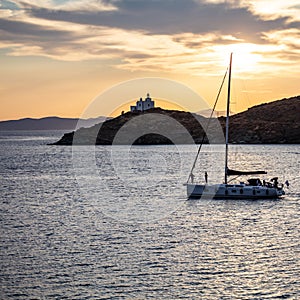 Sailing at sunset, Mediterranean sea. Lighthouse at Kea island, Greece