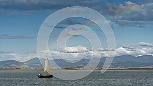 Sailing under a rainbow by Motueka sandspit, Tasman region, New Zealand