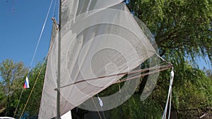 Sailing. White sail in close-up against sky. Catamaran before sailing to sea. Start of sports competitions. Regatta