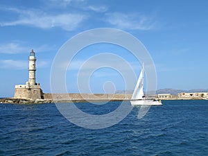 Sailing White Yacht near the Lighthouse on the Blue Aegean Sea, Crete Island, Greece