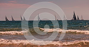 Sailing wind boats and sea waves rolling on the beach sand. Summer vacation