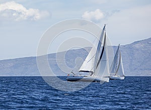 Sailing in the wind through the waves at the Aegean Sea in Greece. Luxury yachts.