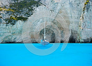 Sailing yacht in the bay. Rocks and bright turquoise sea water. Azure water in the Mediterranean Sea.