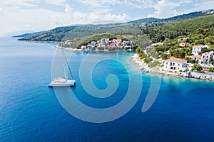 Sailing yacht boat in blue sea arrive Fiscardo village in Kefalonia island, Greece