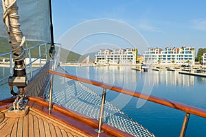 Sailing yacht boat at sunrise with modern town in the background