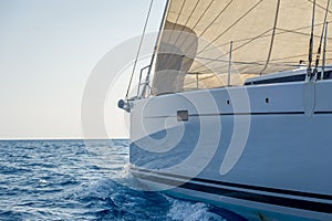 Sailing yacht bow with hoisted headsail.