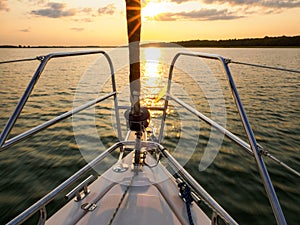 Sailing yacht bow in sunset light, sailing on a lake