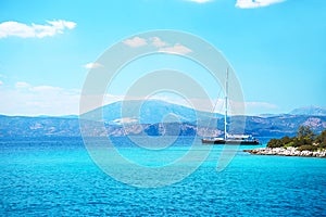 Sailing yacht catamaran boat with white sails on turquoise waters of sea.