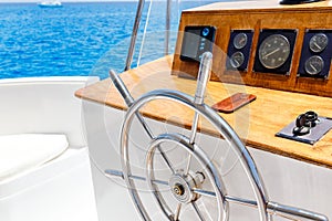 Sailing yacht control wheel and navigation implement.