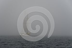 Sailing yacht in deep fog over sea