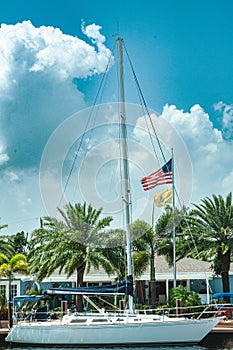 Sailing yacht at dock side, in a tropical harbor, flying American flag