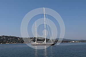 sailing yacht with furled sails and the light reflecting on the hull