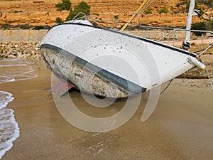 The sailing yacht lies tilted on a sandy beach photo