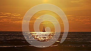 Sailing yacht in the light of sunset. Sailboat pleasurecraft in the sea. Traveling, journey, summer concept.