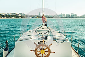 Sailing yacht moves along the sea towards the coast. Travel vacation adventure concept