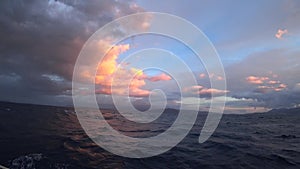 Sailing yacht on the open sea. Dramatic twilight sky over the waves. Slow mo