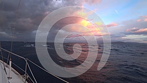 Sailing yacht on the open sea. Dramatic twilight sky over the waves. Slow mo