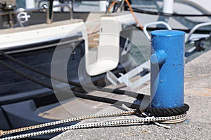 Sailing yacht ropes tied to marina bollard