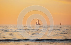 Sailing yacht on sunrise. Calm sea with sunset sky and sun through the clouds over. Ocean and sky background, seascape.