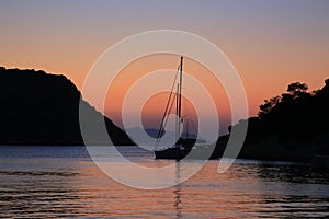 Sailing yacht at sunset anchored