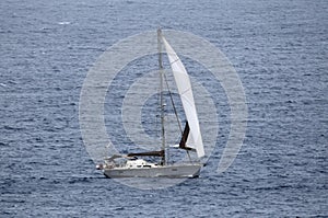 Sailing yacht with white sail on open water