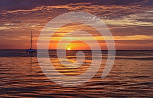 Sailing and yachting at sea. Boat on water at sunset. Sailboats with sails. Ocean water.