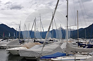 Sailing yachts in a marina covered for winter season and with lowered sails.