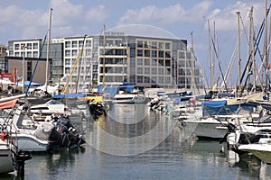 Sailing yachts and modern buildings in Herzliya Marina, Israel.