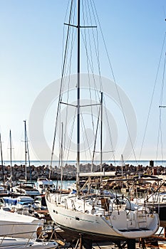 Sailing yachts and pleasure boats stand moored in port