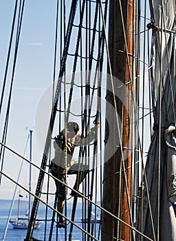 Sailor climbing ship rigging