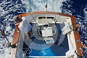 Sailor gets ready reels and rods for game fishing at sea near Saint-Denis, Reunion island.