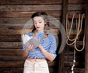 Sailor girl with striped copybook and sailor`s striped vest