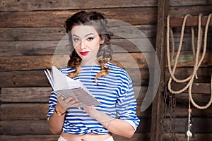 Sailor girl with striped copybook and sailor`s striped vest