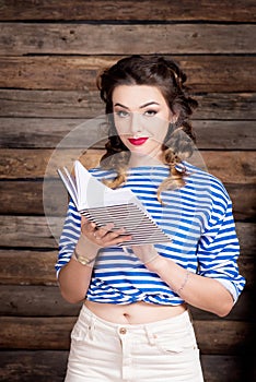 Sailor girl with striped copybook and sailor`s striped vest