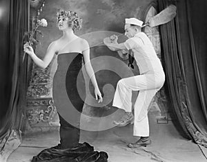 Sailor hitting elegant woman with broom photo