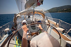 Sailor holding the helm of the sailboat