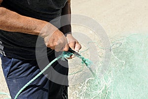 Sailor preparing the fishing nets in the fishing port of Rota, coast of CÃ¡diz, Spain.