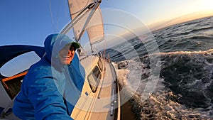 Sailor recording selfie from Sailboat in open cold sea. Concept of travel, adventure, risk and adrenaline
