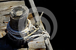 Sailor rope and knot on a wooden pier at the seaside - black backgound for writing