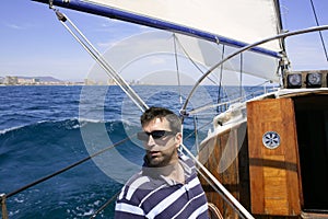 Sailor sailing blue tropical sea on sailboat