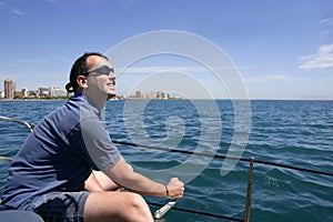 Sailor sailing blue tropical sea on sailboat