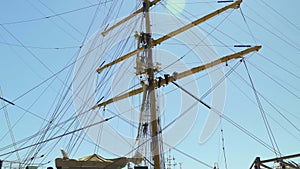 Sailors climb down a match on a beautiful sailing ship in port 4k