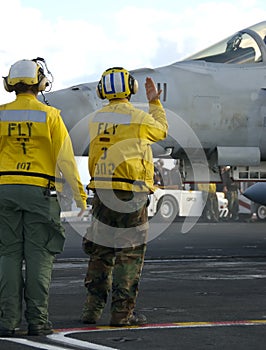 Sailors at work on flight deck photo