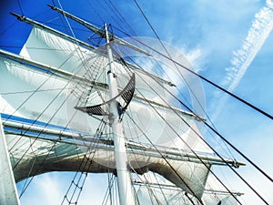 Sails, mast and ropes view from below of a classic sailing ship.