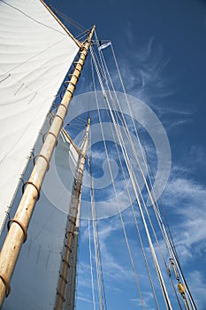Sails and Wooden Masts of Old Schooner Sailboat Reaching to Blue